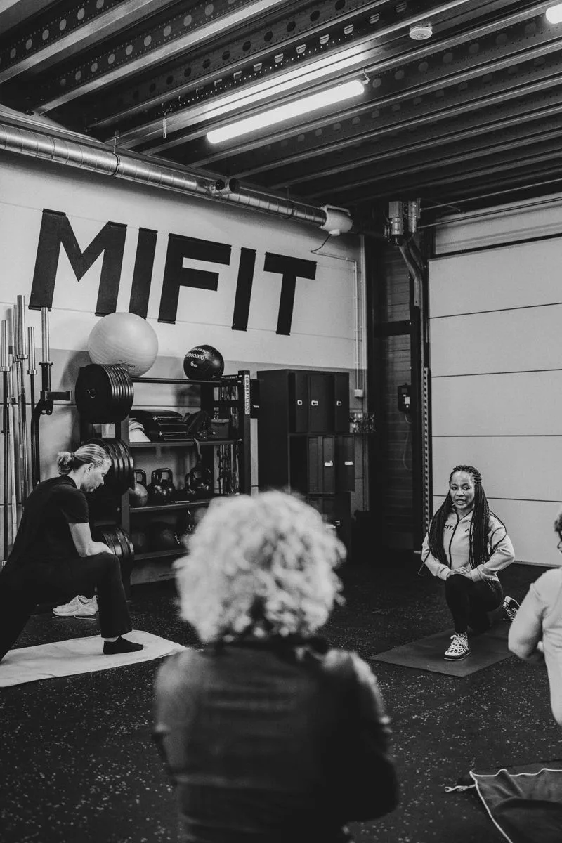Een Small Group Training in de studio, met het Mifit-logo op de wand
