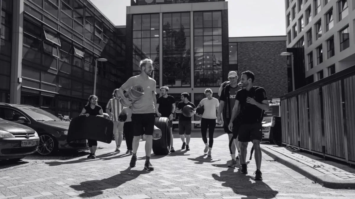 Collega's tijdens een bedrijfsbootcamp buiten tussen de kantoren