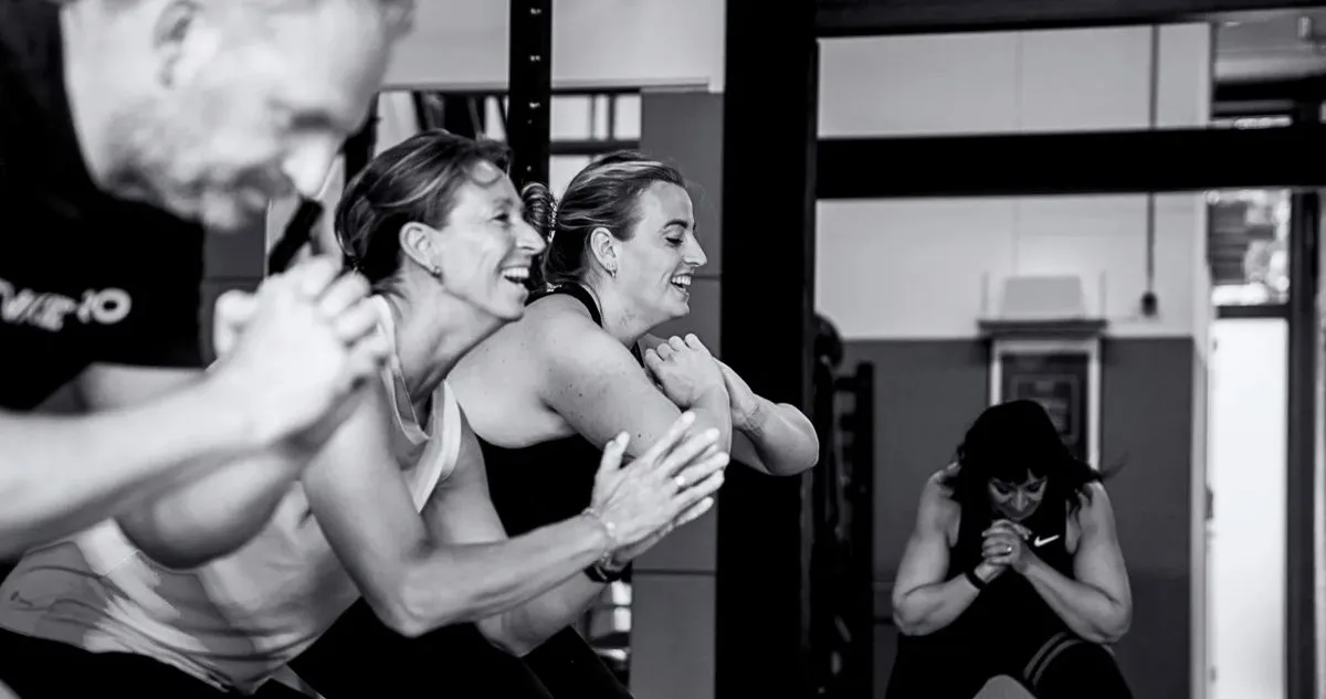 Twee leden trainen lachend samen