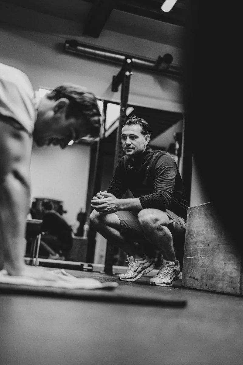 Een personal trainer begeleidt een klant bij push-ups